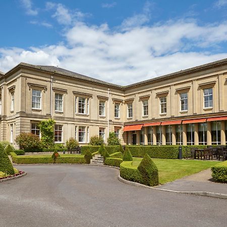 Macdonald Bath Spa Hotel Екстериор снимка The photo depicts a large, elegant building with a classic architectural style, featuring a combination of stone and large windows. The structure appears to have two sections: a main, stately part on the left and an adjoining section that has a terra