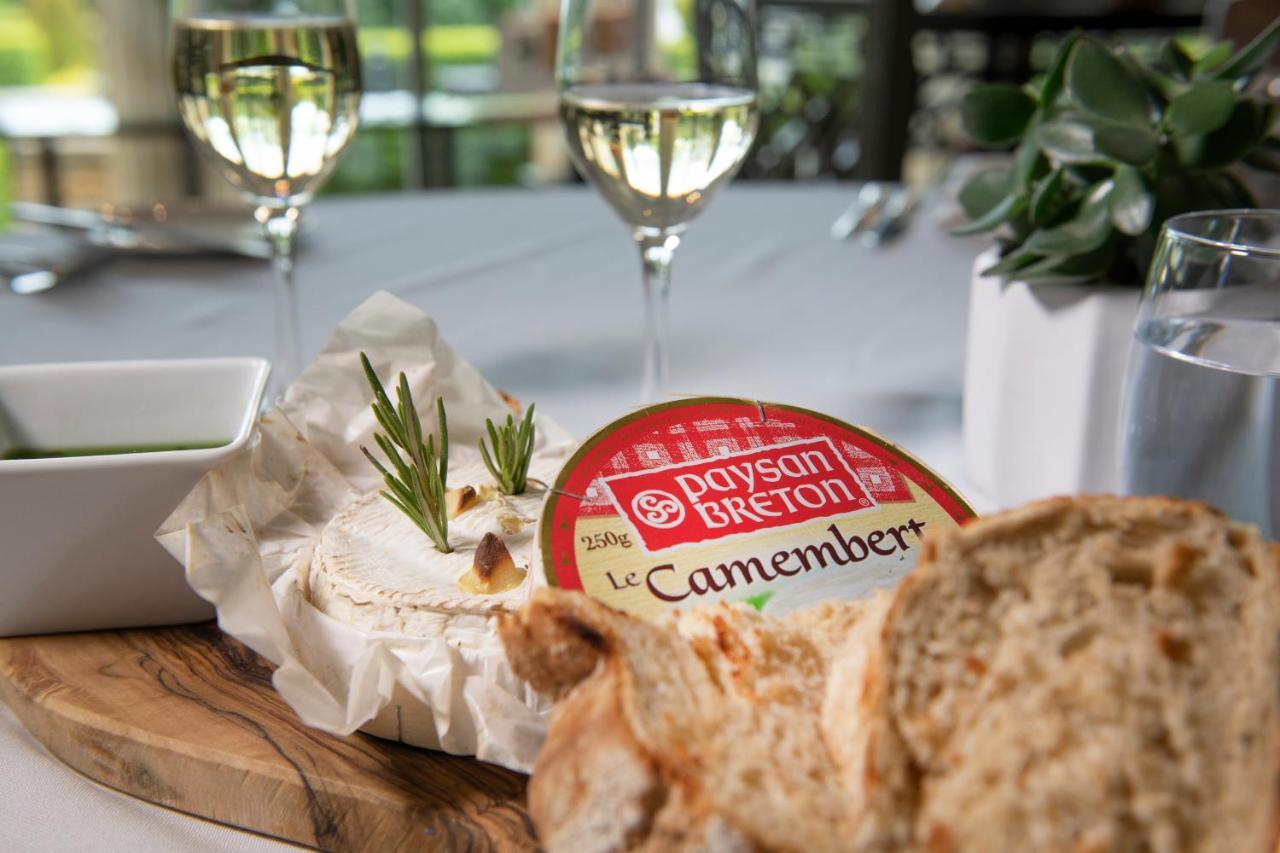 Macdonald Bath Spa Hotel Екстериор снимка The photo features a dining setting that includes a wooden platter with a round Camembert cheese, garnished with fresh rosemary sprigs. Nearby, there is a serving of bread, likely sliced, and a small bowl, potentially for dipping or spreading. In the