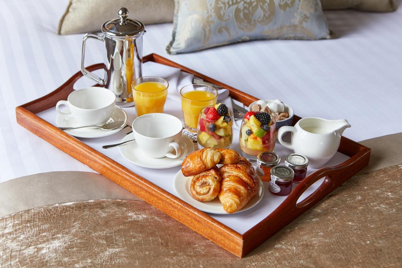 Macdonald Bath Spa Hotel Екстериор снимка The photo shows a wooden tray arranged with a delightful breakfast spread. On the tray, there are two cups, a coffee pot, and several glasses of orange juice. There's also a small bowl of mixed fruit, featuring various colorful pieces. Additionally, 