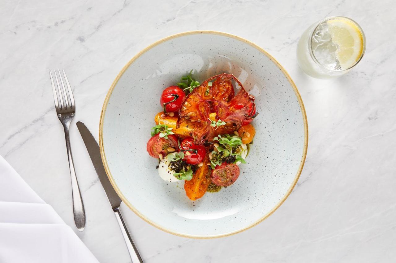 Macdonald Bath Spa Hotel Екстериор снимка The photo shows a beautifully arranged plate of food. The dish features a mix of colorful ingredients, including roasted or grilled vegetables, likely bell peppers and tomatoes, along with fresh greens. There are also some circular slices of another 