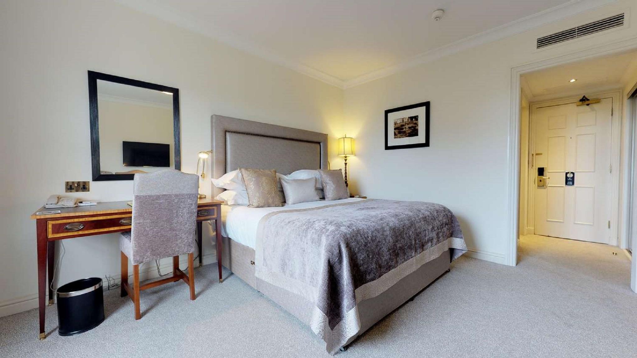 Macdonald Bath Spa Hotel Екстериор снимка The photo shows a well-decorated hotel room. In the center, there's a comfortable bed with plush bedding and decorative pillows. A bedside table with a lamp is positioned next to the bed. To the left, there's a small desk with a chair, accompanied by