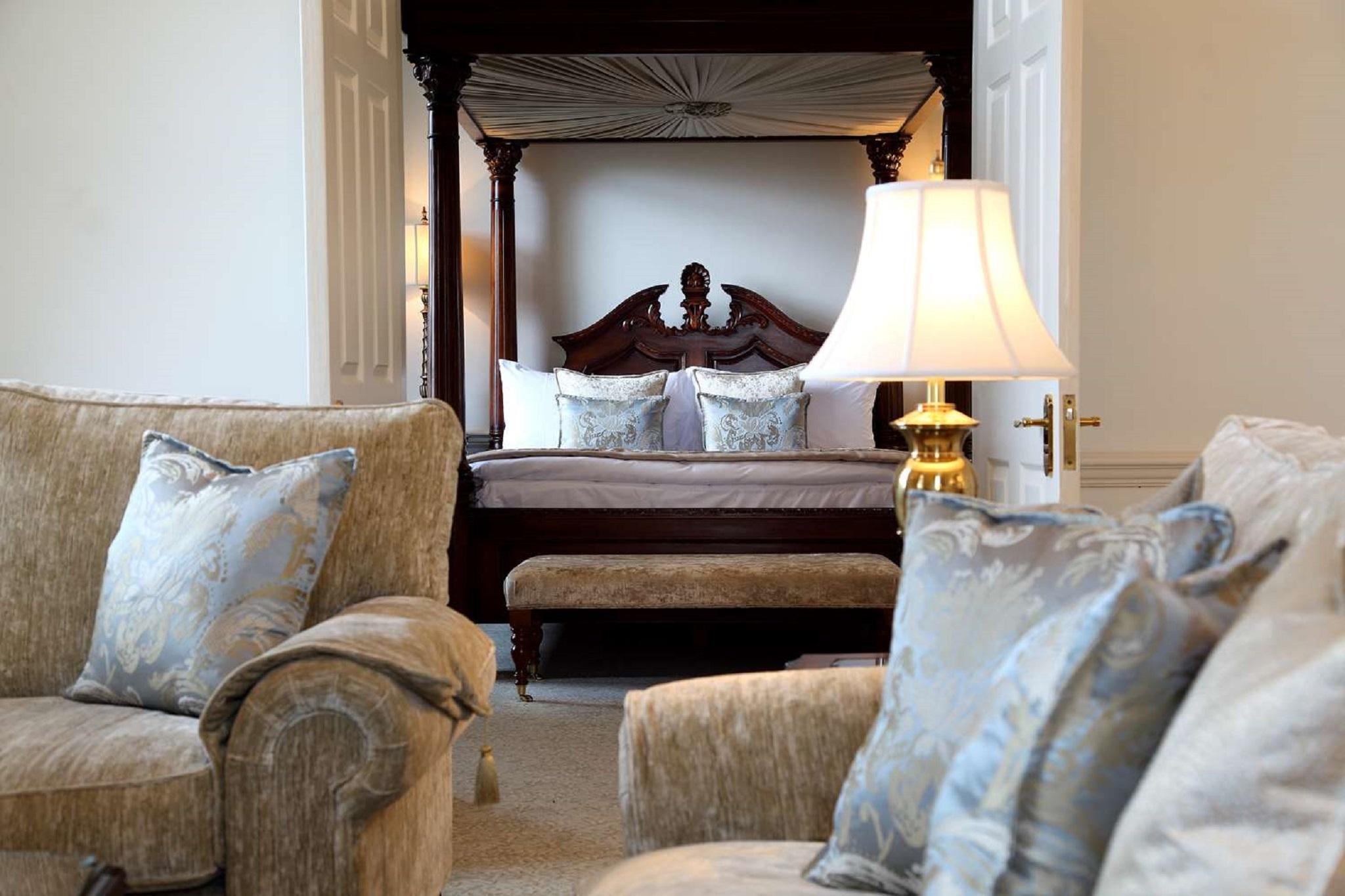 Macdonald Bath Spa Hotel Екстериор снимка The photo shows a beautifully decorated room featuring a four-poster bed in the background. The bed has a wooden frame with a rich design, and it is adorned with plush bedding and pillows. In the foreground, there are comfortable sofas with decorativ