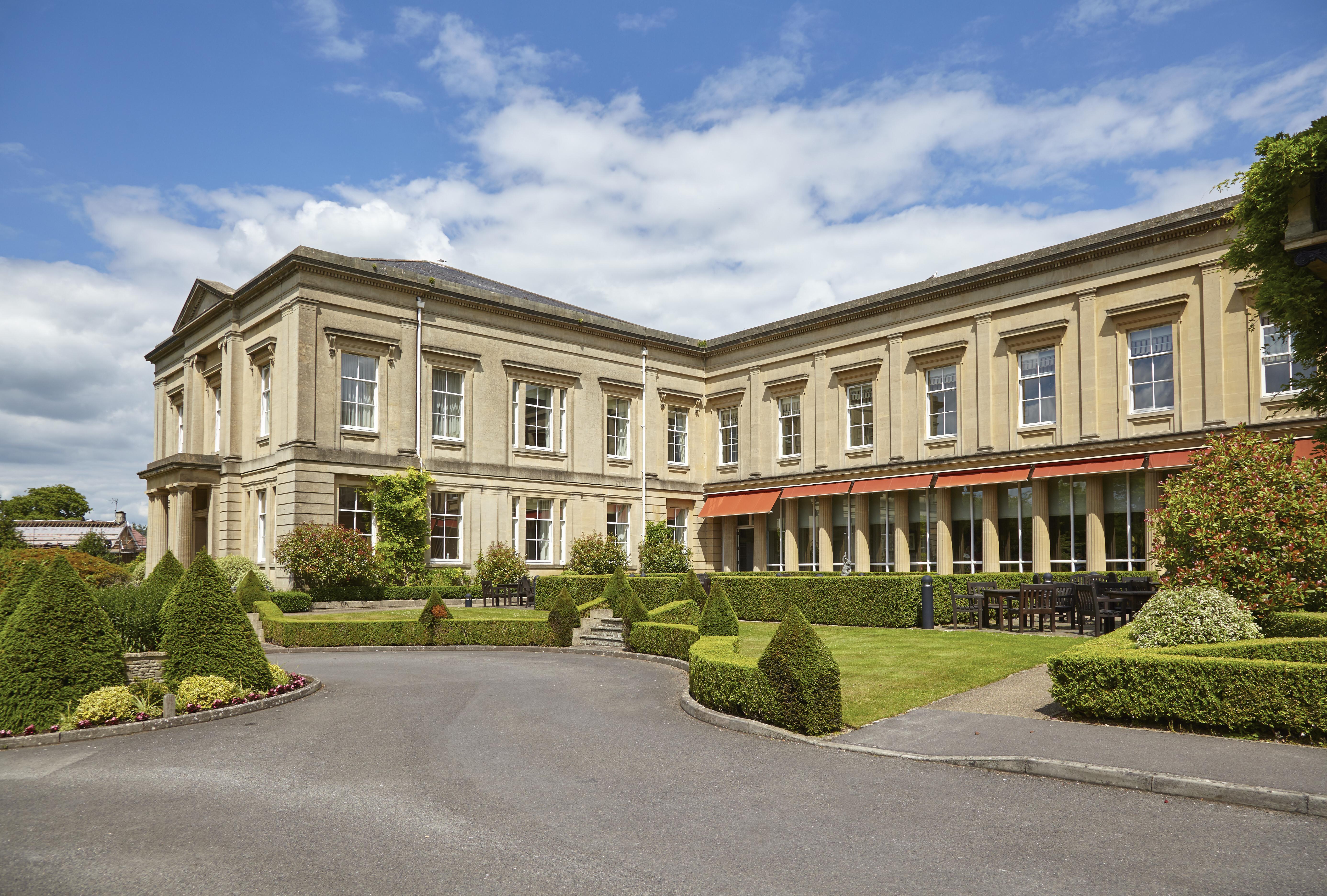 Macdonald Bath Spa Hotel Екстериор снимка The photo depicts a large, elegant building with a classic architectural style, featuring a combination of stone and large windows. The structure appears to have two sections: a main, stately part on the left and an adjoining section that has a terra