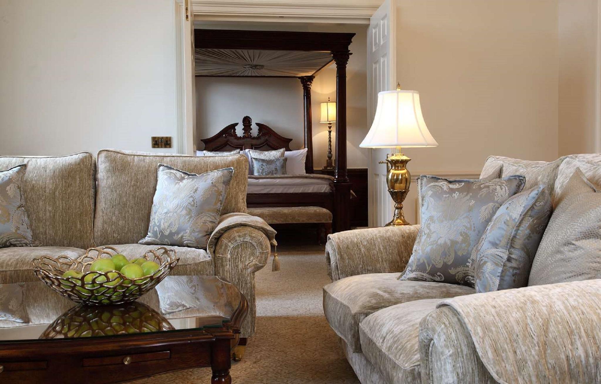 Macdonald Bath Spa Hotel Екстериор снимка The photo shows a cozy living space with elegant furnishings. On the left, there is a sofa with plush cushions and a stylish armchair, both in a soft, light-colored fabric. In the center, there is a decorative glass table with a bowl containing what 